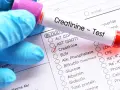 Ręka w niebieskiej rękawiczce trzyma probówkę z krwią do testu na kreatyninę. Zaznaczono opcję "Creatinine", sugerując podwyższoną kreatyninę.
