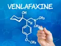Rysunek chemiczny wenlafaksyny, leku znanego jako velaxin, na niebieskim tle z wzorami chemicznymi.