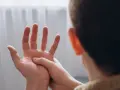 Mężczyzna masuje dłoń, odczuwając drętwienie rąk.