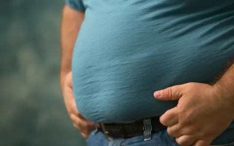 Mężczyzna z widocznym brzuchem, który może być oznaką zespołu metabolicznego.
