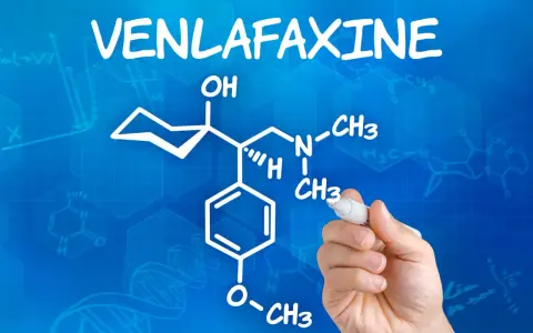 Rysunek chemiczny wenlafaksyny, leku znanego jako velaxin, na niebieskim tle z wzorami chemicznymi.
