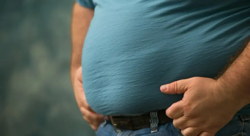 Mężczyzna z widocznym brzuchem, który może być oznaką zespołu metabolicznego.