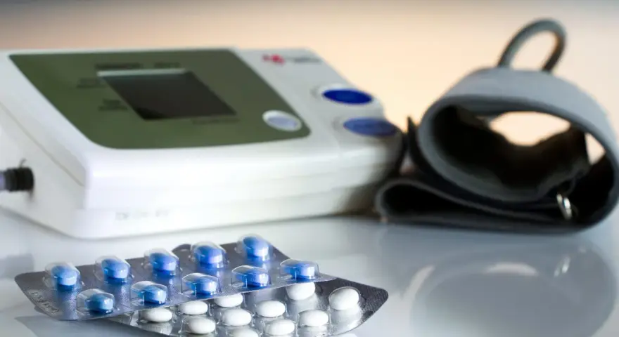 Ciśnieniomierz i opakowania leków, w tym niebieskie tabletki, mogą być częścią terapii z prestarium.