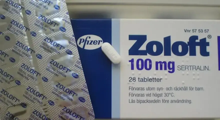 Opakowanie leku Zoloft 100 mg z sertraliną i pojedyncza tabletka. Lek ten pomaga w leczeniu depresji.